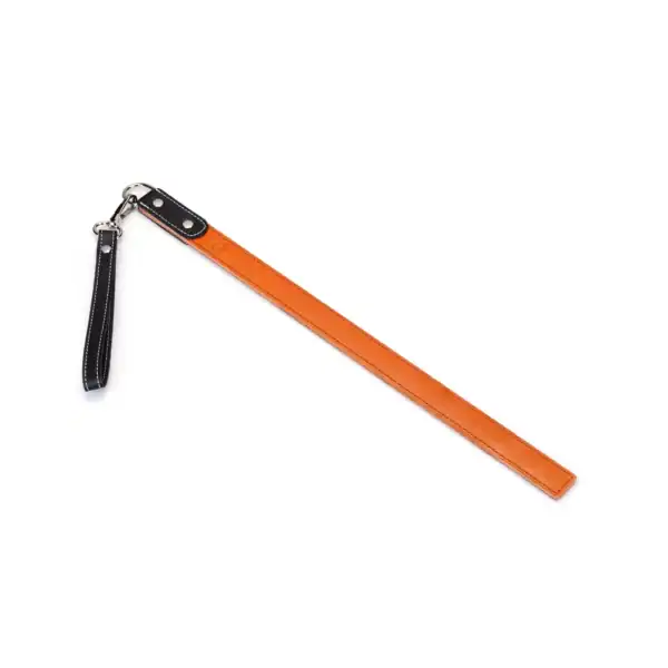 LIEBE SEELE regla de azotar de cuero naranja con asa y correa, costuras en contraste, presentada sobre fondo blanco