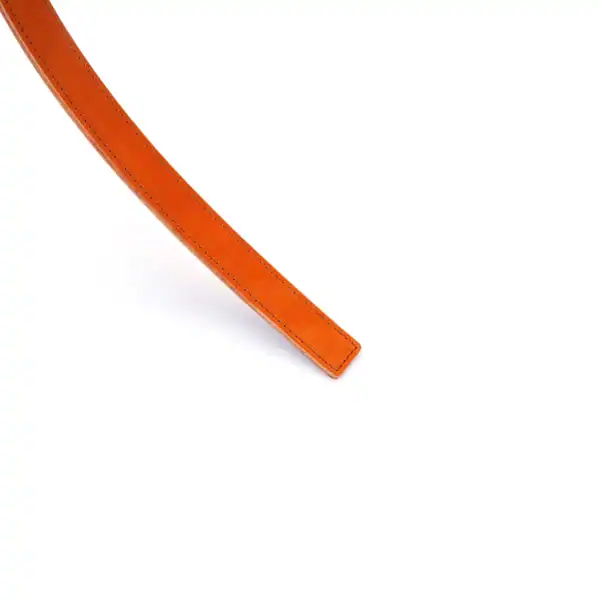 LIEBE SEELE regla de azotar de cuero naranja con asa y correa, costuras en contraste, presentada sobre fondo blanco