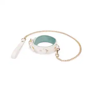 Boudoir Amor leash necklace by Liebe Seele, in light-colored leather with contrasting interior and gold-tone metal chain, presented flat on a light-colored background in the Brigade Mondaine Paris universe.