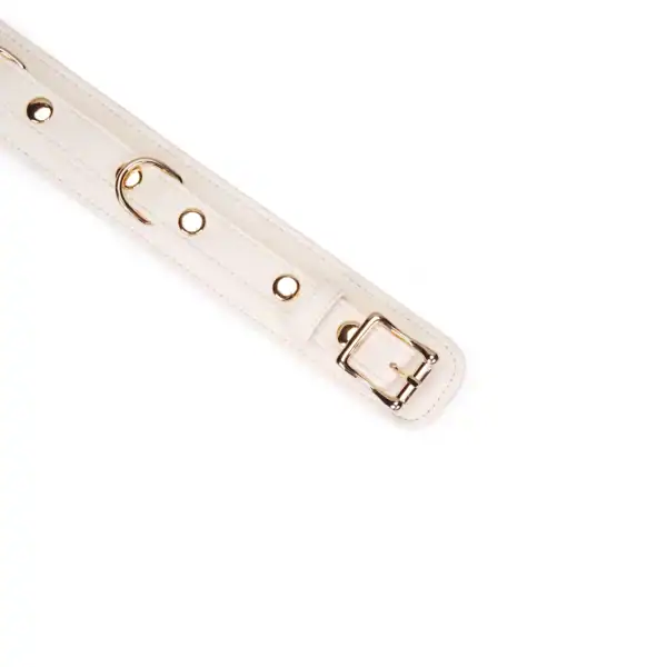 Amor Boudoir-Leinenhalskette der Marke Liebe Seele aus hellem Leder mit kontrastierender Innenseite und goldener Metallkette, flach auf hellem Hintergrund in der Welt Brigade Mondaine Paris präsentiert.