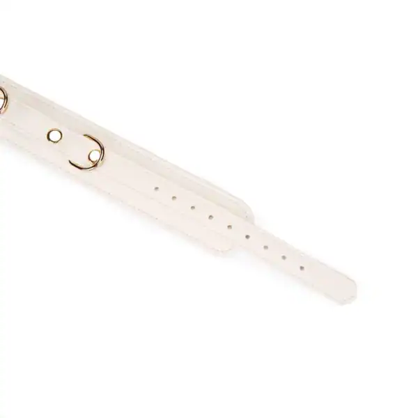 Boudoir Amor leash necklace by Liebe Seele, in light-colored leather with contrasting interior and gold-tone metal chain, presented flat on a light-colored background in the Brigade Mondaine Paris universe.