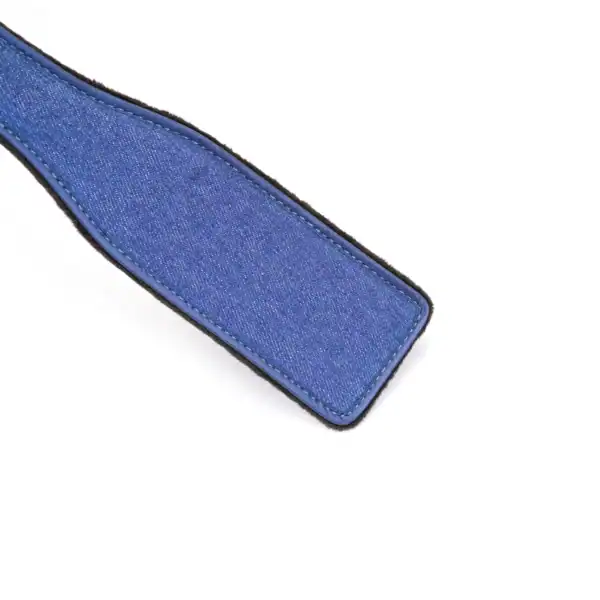 Paddle en denim de la marque Liebe Seele, à la forme allongée avec lanière de maintien, présenté sur fond clair dans l’univers Brigade Mondaine Paris.