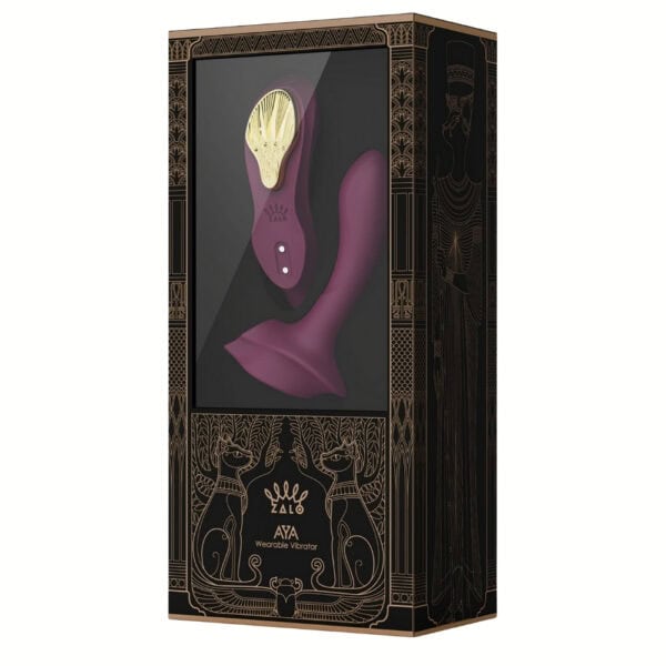 Plum-colored portable vibrator with gold details, ergonomic design and integrated controls, presented on a white background, selection Brigade Mondaine Paris.