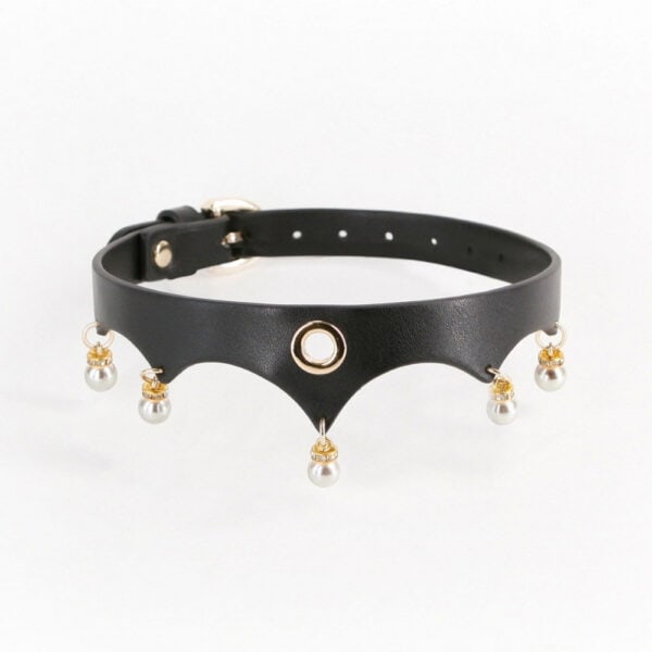 Close-up of a black leather BDSM necklace worn around the neck, adorned with gold rings and white beads, against a dark background, in an elegant, minimalist aesthetic.