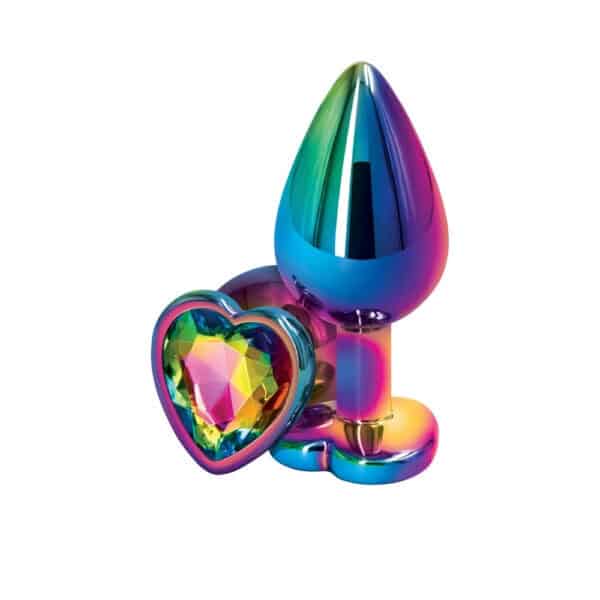 Analplug in mehrfarbigem Kristall mit dekorativer Basis in Form eines facettierten Herzens, präsentiert auf dunklem Hintergrund mit Lichteffekten und irisierenden Reflexen.