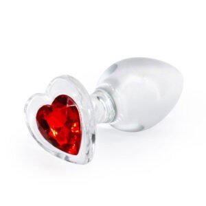 Un tapón anal de cristal transparente sobre fondo negro, con una base decorativa en forma de corazón rojo facetado para un aspecto elegante y refinado.