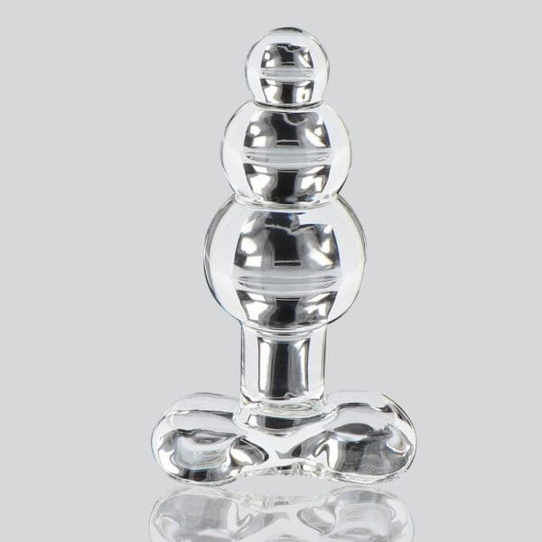 Analplug aus durchsichtigem Glas mit facettierter Form und ausladender Basis, dargestellt auf klarem Hintergrund, glänzendes Finish, Auswahl Brigade Mondaine Paris.