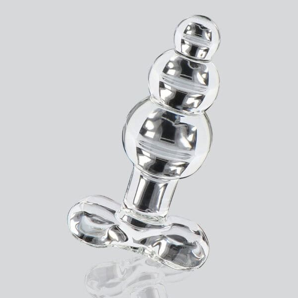 Analplug aus durchsichtigem Glas mit facettierter Form und ausladender Basis, dargestellt auf klarem Hintergrund, glänzendes Finish, Auswahl Brigade Mondaine Paris.
