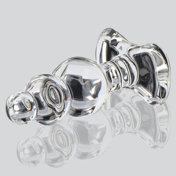 Analplug aus durchsichtigem Glas mit facettierter Form und ausladender Basis, dargestellt auf klarem Hintergrund, glänzendes Finish, Auswahl Brigade Mondaine Paris.