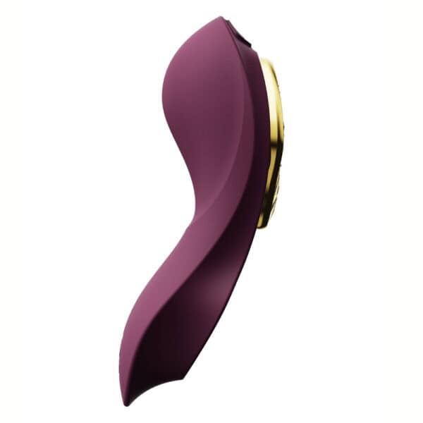 Plum-colored portable vibrator with gold details, ergonomic design and integrated controls, presented on a white background, selection Brigade Mondaine Paris.