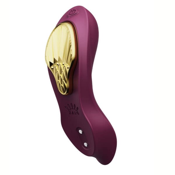 Plum-colored portable vibrator with gold details, ergonomic design and integrated controls, presented on a white background, selection Brigade Mondaine Paris.