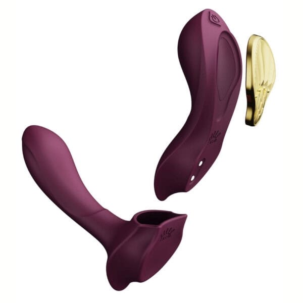 Plum-colored portable vibrator with gold details, ergonomic design and integrated controls, presented on a white background, selection Brigade Mondaine Paris.