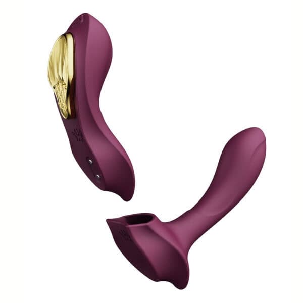 Plum-colored portable vibrator with gold details, ergonomic design and integrated controls, presented on a white background, selection Brigade Mondaine Paris.