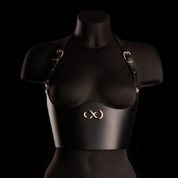 Bustier Neria negro de piel IINFYNII presentado en Brigade Mondaine Paris, colocado sobre un maniquí, entallado bajo el busto, tirantes finos ajustables y joya central dorada.
