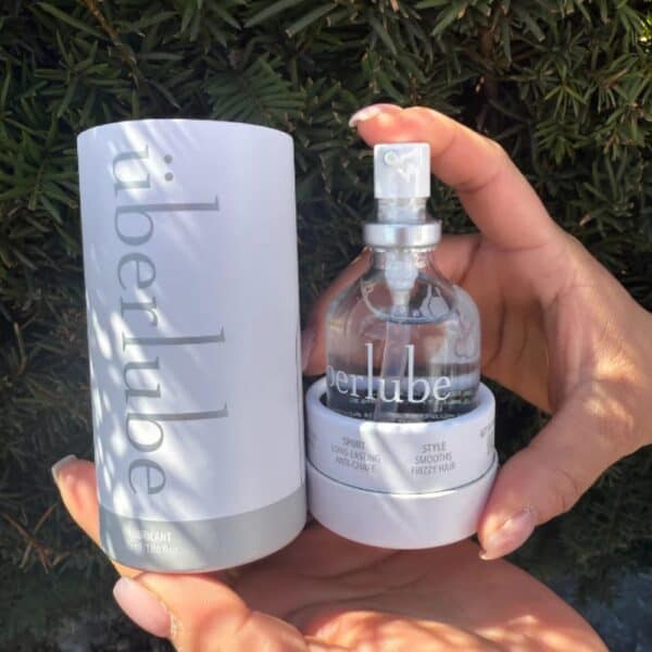 Lubrifiant Luxe Überlube Flacon en verre de lubrifiant luxe transparent avec spray, présenté avec son étui cylindrique blanc, sélection Brigade Mondaine Paris.