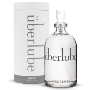Botella de cristal de lubricante de lujo transparente con pulverizador, presentada con su estuche cilíndrico blanco, selección Brigade Mondaine Paris.
