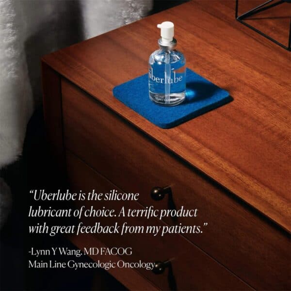 Lubrifiant Luxe Überlube Flacon en verre de lubrifiant luxe transparent avec spray, présenté avec son étui cylindrique blanc, sélection Brigade Mondaine Paris.