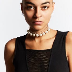 Modèle portant le Boudoir Choker Perlensau avec perles blanches montées sur base transparente, proposé par Brigade Mondaine Paris.