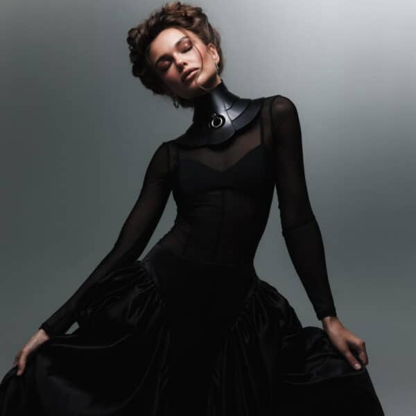 Halsband Posture Hold RE:STRICT Brigade Mondaine Paris Model trägt die RE:STRICT Posture Hold Halskette aus schwarzem Leder bei Brigade Mondaine Paris, ein steifes Stück, das den Hals bedeckt, zentraler Metallring, getragen mit einem schwarzen Mesh-Top im Studio.
