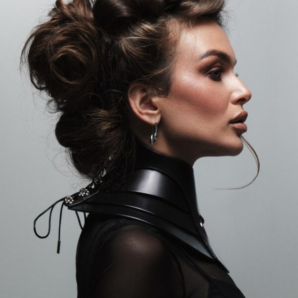 Halsband Posture Hold RE:STRICT Brigade Mondaine Paris Model trägt die RE:STRICT Posture Hold Halskette aus schwarzem Leder bei Brigade Mondaine Paris, ein steifes Stück, das den Hals bedeckt, zentraler Metallring, getragen mit einem schwarzen Mesh-Top im Studio.