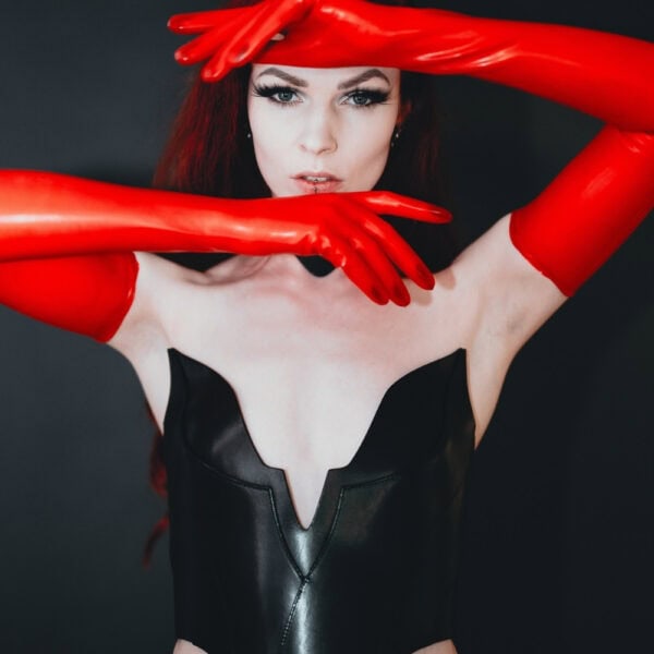Nyx-Lederkorsett RE:STRICT Brigade Mondaine Paris Model trägt das rote RE:STRICT Nyx-Lederkorsett bei Brigade Mondaine Paris, strukturiertes Dekolleté, getragen mit passender Halskette und schwarzen Accessoires, fotografiert im Studio.