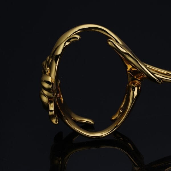 UPKO „Ripple“ Metallhandschellen Brigade Mondaine Paris Goldene Handschellen der Marke UPKO mit kunstvollem Design und glänzenden Metalloberflächen, die in der raffinierten Welt von Brigade Mondaine Paris an den Handgelenken getragen werden.