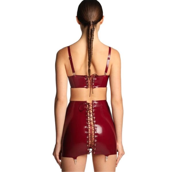Short skirt in shiny burgundy latex with criss-cross lacing at back and garter belt fastenings.