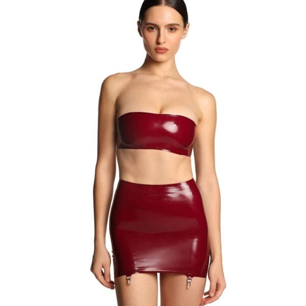 Short skirt in shiny burgundy latex with criss-cross lacing at back and garter belt fastenings.