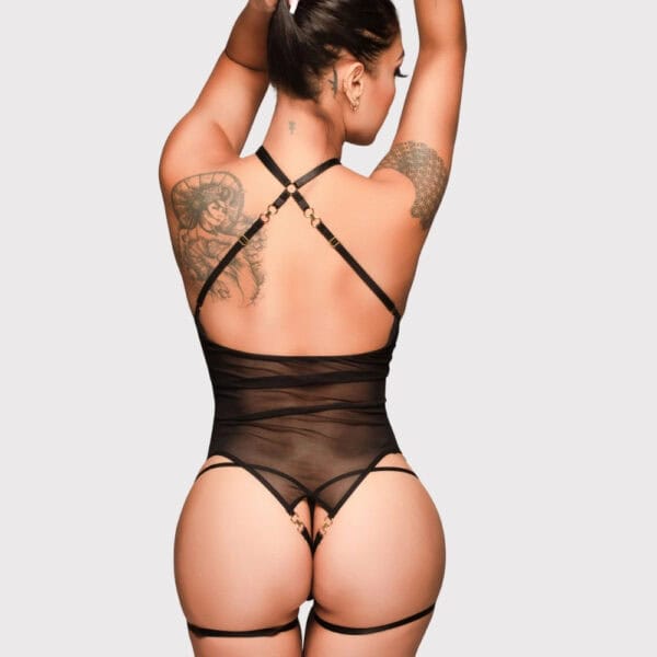Offener Body aus schwarzem Mesh-Material mit überkreuzten Riemen an der Büste und Strapsgürtelverschlüssen.