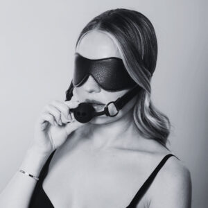 Bandeau en cuir noir avec sangle élastique et gag en silicone noir intégré, accessoire BDSM proposé par Brigade Mondaine Paris.