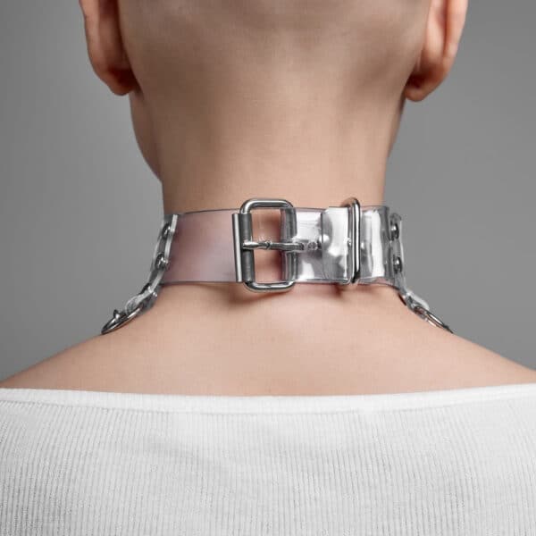 Modelo que lleva el Cosmic Choker Perlensau en material transparente con cadenas de metal y colgantes, ofrecido por Brigade Mondaine Paris.