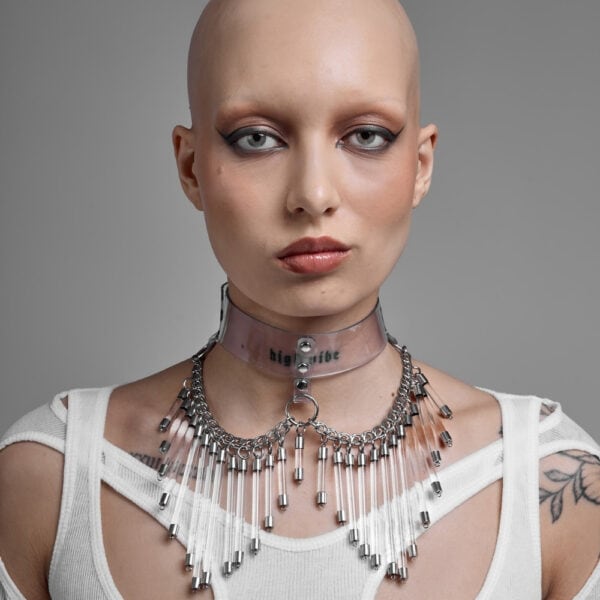 Modelo que lleva el Cosmic Choker Perlensau en material transparente con cadenas de metal y colgantes, ofrecido por Brigade Mondaine Paris.