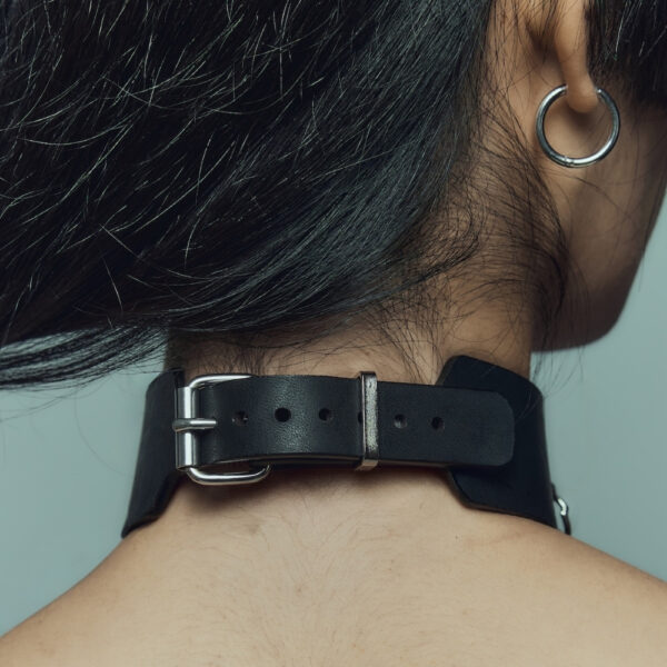 La modelo lleva la gargantilla Dedication Perlensau de piel negra con cadena de metal plateado, ofrecida por Brigade Mondaine Paris.