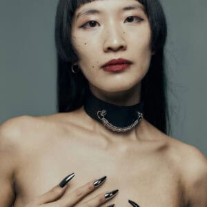 Modèle portant le Dedication Choker Perlensau en cuir noir avec chaîne métallique argentée, proposé par Brigade Mondaine Paris.