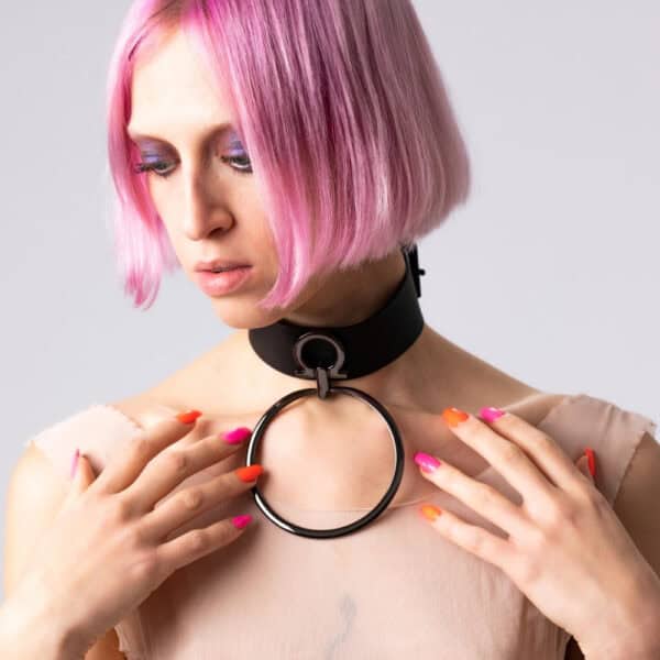 Modelo que lleva la gargantilla Divine Perlensau de cuero negro con gran anillo metálico suspendido, ofrecida por Brigade Mondaine Paris.