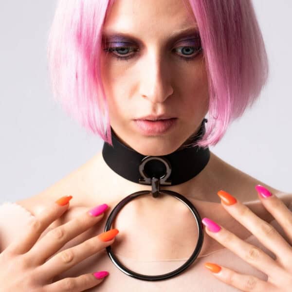 Modelo que lleva la gargantilla Divine Perlensau de cuero negro con gran anillo metálico suspendido, ofrecida por Brigade Mondaine Paris.