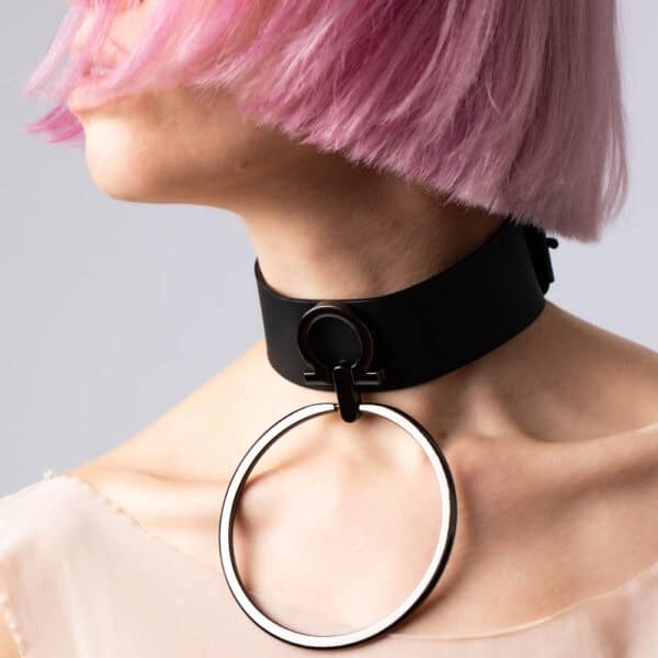 Modelo que lleva la gargantilla Divine Perlensau de cuero negro con gran anillo metálico suspendido, ofrecida por Brigade Mondaine Paris.
