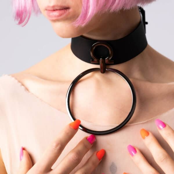 Modelo que lleva la gargantilla Divine Perlensau de cuero negro con gran anillo metálico suspendido, ofrecida por Brigade Mondaine Paris.