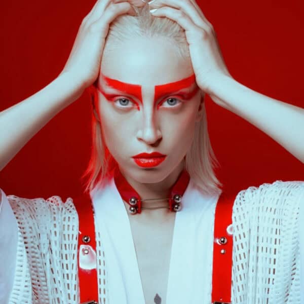 На модели красный чокер Perlensau Industrial Choker из кожи с металлическими шипами и серебряными сферами, предложенный Brigade Mondaine Paris.