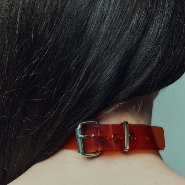 На модели красный чокер Perlensau Industrial Choker из кожи с металлическими шипами и серебряными сферами, предложенный Brigade Mondaine Paris.