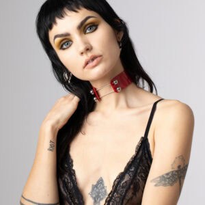 Model wearing Perlensau red Industrial Choker in leather with metal rods and silver spheres, offered by Brigade Mondaine Paris.