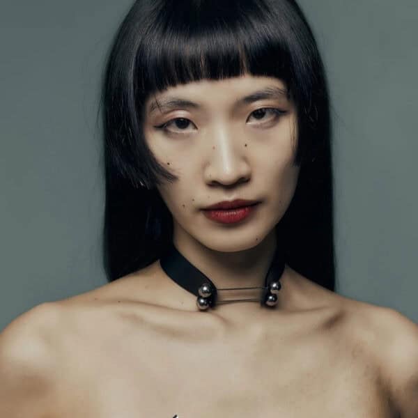 Modelo que lleva la Gargantilla Industrial Perlensau en cuero negro con elementos metálicos plateados, ofrecida por Brigade Mondaine Paris.
