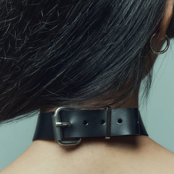 Modelo que lleva la Gargantilla Industrial Perlensau en cuero negro con elementos metálicos plateados, ofrecida por Brigade Mondaine Paris.