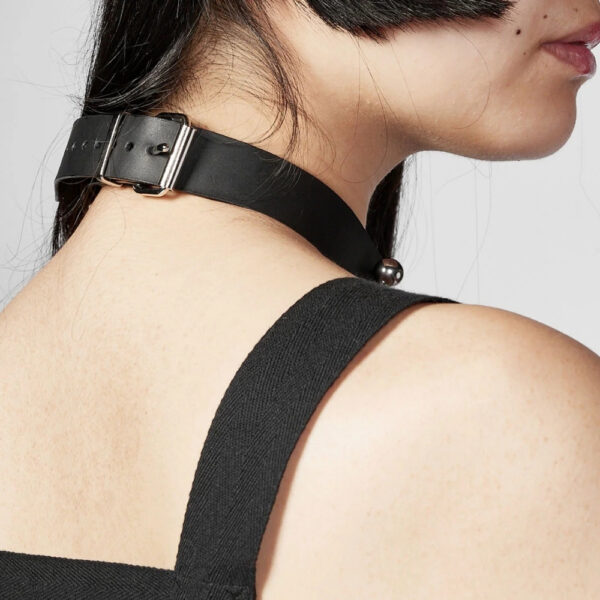 Modelo que lleva la Gargantilla Industrial Perlensau en cuero negro con elementos metálicos plateados, ofrecida por Brigade Mondaine Paris.