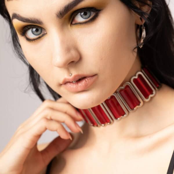 Modèle portant le Bulletproof Choker rouge Perlensau avec plaques rouges translucides et structure métallique, proposé par Brigade Mondaine Paris.
