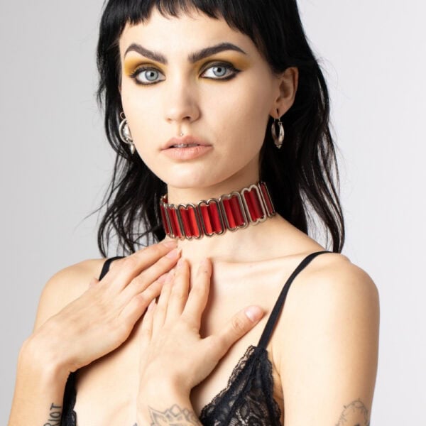 Modèle portant le Bulletproof Choker rouge Perlensau avec plaques rouges translucides et structure métallique, proposé par Brigade Mondaine Paris.