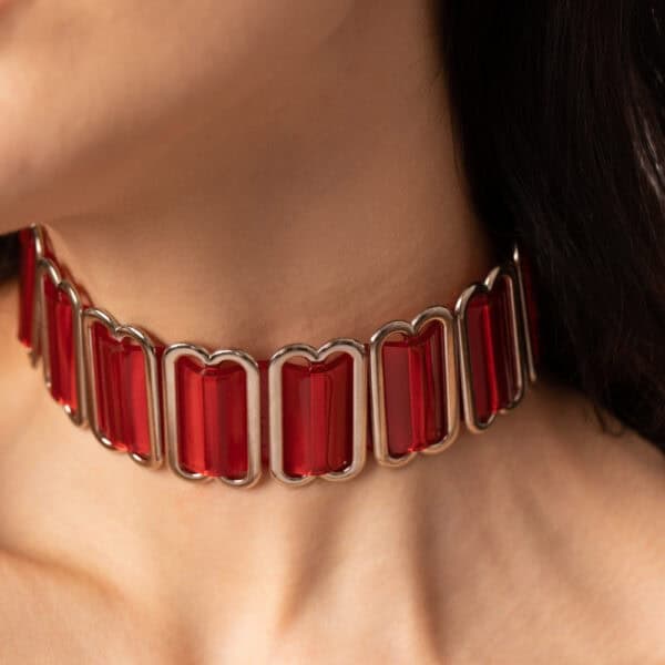 Modèle portant le Bulletproof Choker rouge Perlensau avec plaques rouges translucides et structure métallique, proposé par Brigade Mondaine Paris.
