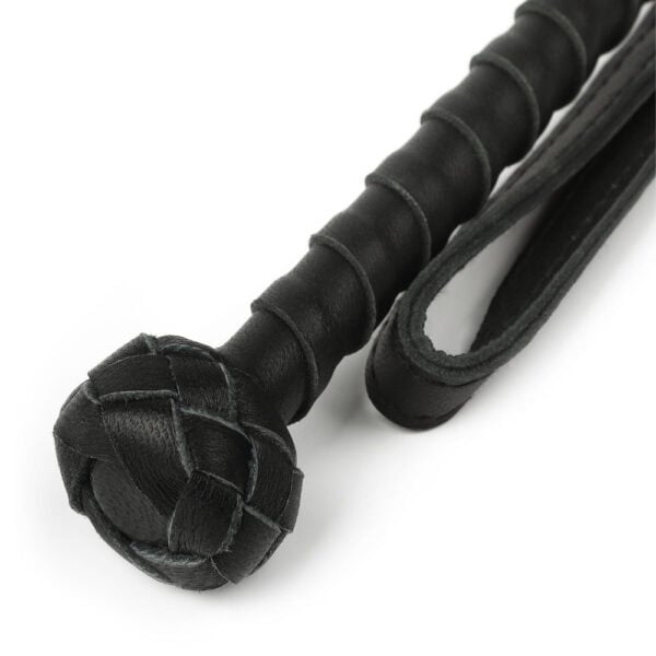 Bastón Obediance de madera clara con empuñadura de cuero negro y correa de mano a juego, accesorio ofrecido por Brigade Mondaine Paris.